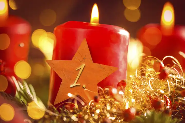 Symbolbild Erster Advent Sonntag, rote brennende Kerze mit einem goldenen Stern auf einem Adventskranz. 1 Advents Gruß FOTOMONTAGE