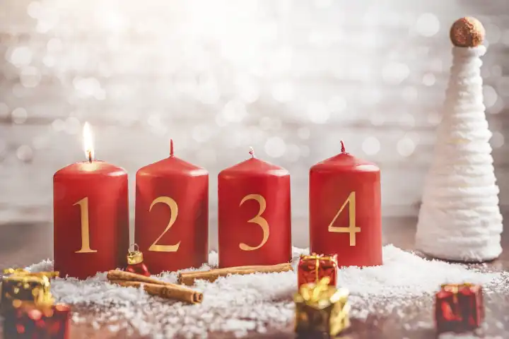 Eine Kerze brennt am ersten Advent, Vier Adventskerzen mit Schnee. Weihnachten und Advents Symbolbild FOTOMONTAGE