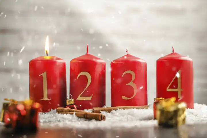 Eine Kerze brennt am ersten Advent, Vier Adventskerzen mit Schnee. Weihnachten und Advents Symbolbild FOTOMONTAGE