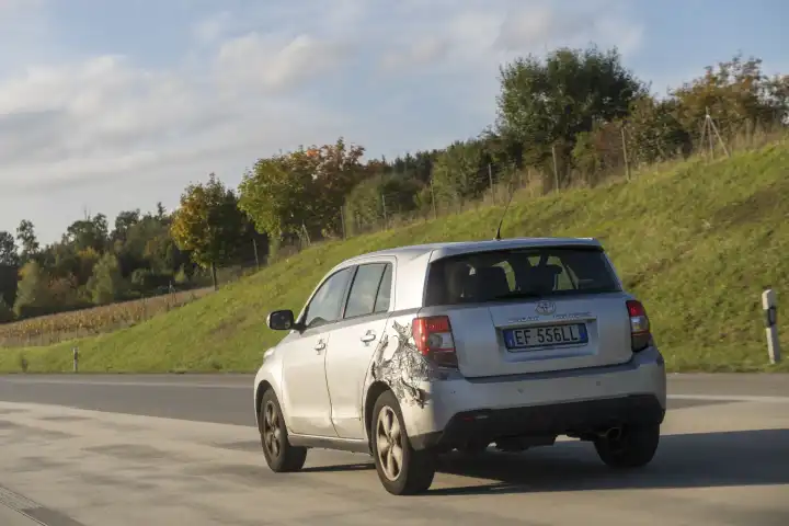 Ein defektes geklebtes Auto fährt auf einer Autobahn