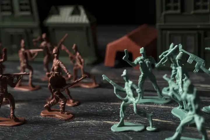 Spielfiguren Soldaten und Panzer auf einem Schlachtfeld. Krieg und Kampf Konzept