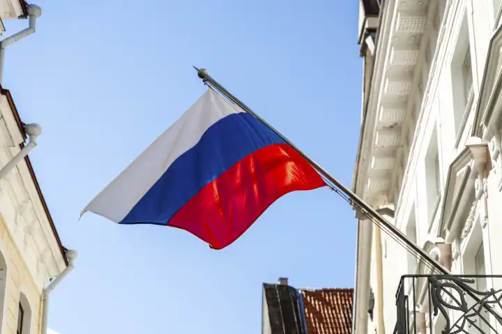 An einem Gebäude weht eine russische Flagge im Wind