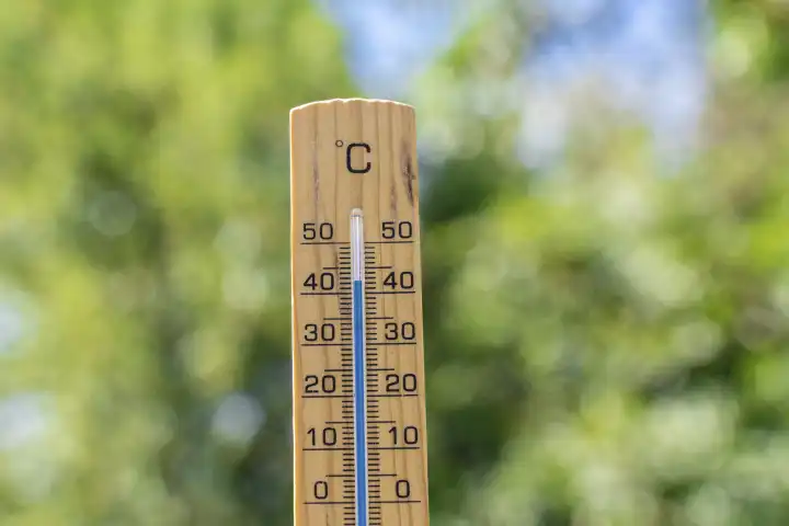 Bavaria, Germany - 20 August 2023: Thermometer made of wood in front of green leaves in nature with the temperature 40 degrees Celsius. Symbol image heat wave