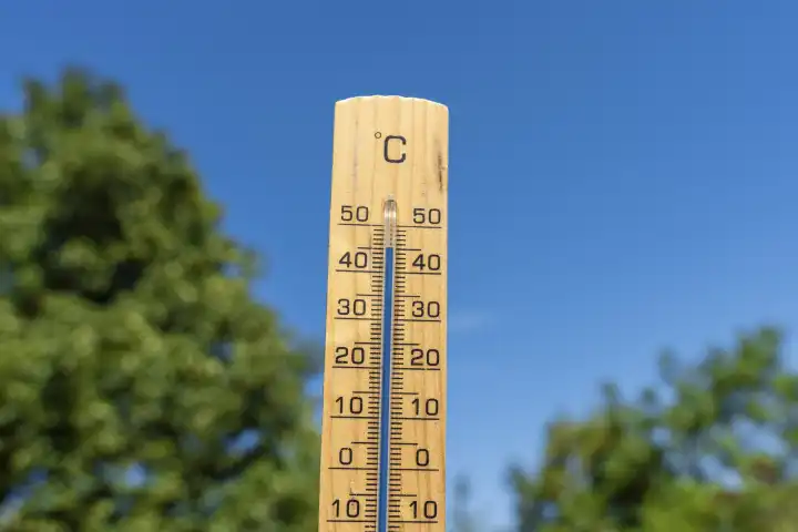 Bavaria, Germany - 20 August 2023: Thermometer made of wood in front of blue sky with temperature 45 degrees Celsius. Symbol image heat wave