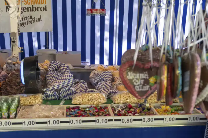 Kempten, Bavaria, Germany - 20 August 2023: Sweets like popcorn, gingerbread hearts and roasted almonds at a confectionery stand at the Allgäuer Festwoche in Kempten