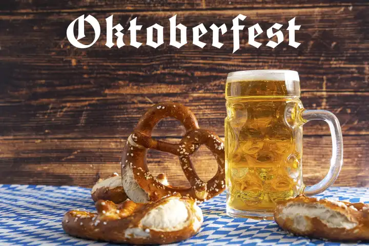 Bavaria, Germany - 25 August 2023: Oktoberfest background, Bavarian flag with beer in Maßkrug and fresh brown pretzels. Wooden background with inscription: Oktoberfest PHOTOMONTAGE