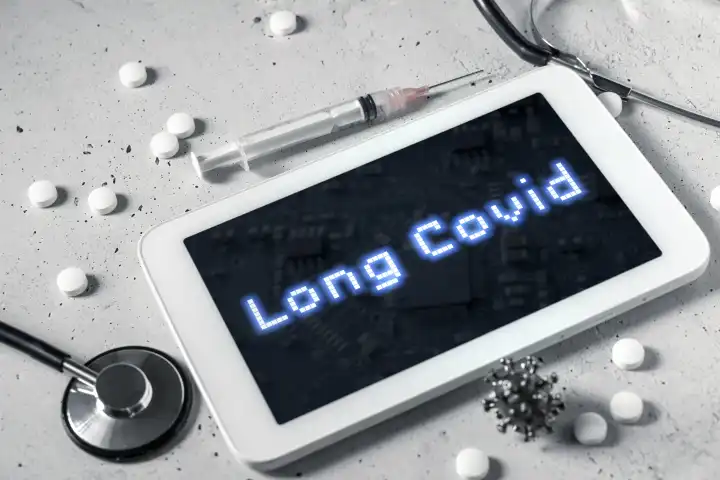 Diagnose Long Covid, Langzeitfolgen nach einer Covid-19 Erkrankung auf dem Display von einem Tablet Computer. Tabletten, Spritze und Stethoskop mit einem Tablet FOTOMONTAGE