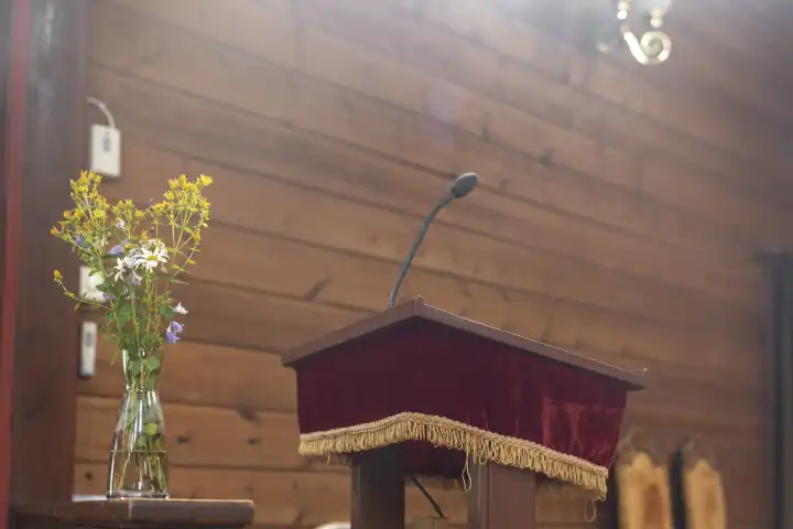 Redepulte in einer Kirche der sogenannte Ambo aus Holz bei Sonnenschein. Glaube und Religion Konzept