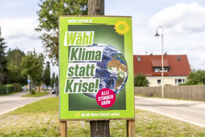 Ein Wahlplakat zur Landtagswahl in Bayern hängt an der Straße in einem Dorf. Die Partei die Grünen werben mit dem Slogan: Wähl Klima statt Krise
