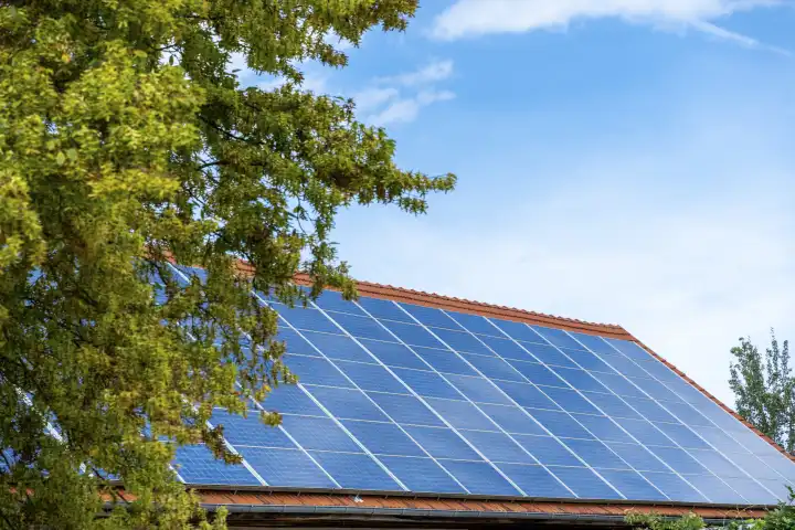 Eine Solaranlage auf dem Dach eines Hauses bei Sonnenschein. Grüne Energie und Strom durch PV Photovoltaik