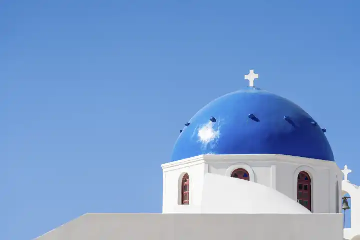 Stadt Oia auf Santorini in Griechenland. Orthodoxe weiße Kirche mit einer blauen Kuppel als Dach mit einem weißen Kreuz