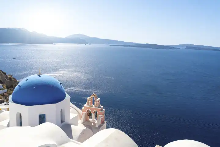 Oia, Santorini, Greece - 20 September 2023: Famous view from the town of Oia in Santorini, Greece. Orthodox white church with a blue dome as a roof with a white cross