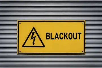 Gelbes Schild mit der Aufschrift: Blackout an einem Metall Gehäuse. Großflächiger Stromausfall FOTOMONTAGE