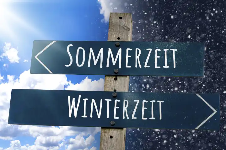 Wegweiser mit der Aufschrift Sommerzeit und Winterzeit vor Himmel mit Sonnenschein und Schnee. Zeitumstellung Symbolbild FOTOMONTAGE 