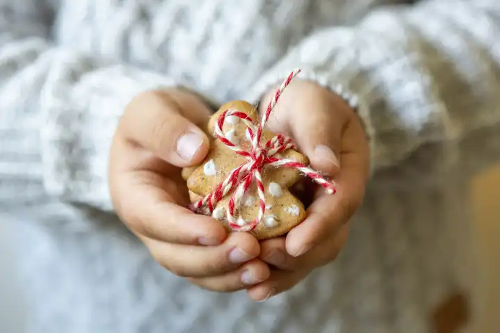 11 August 2023: Child holding cookie cookies for Christmas as a gift. Christmas decoration
