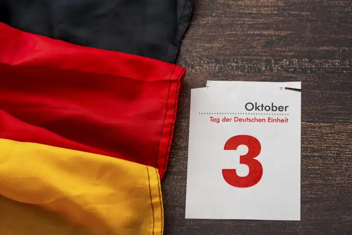 Augsburg, Bavaria, Germany - 30 September 2023: Iconic German Unity Day holiday and bridge day in Germany. Calendar page with 3 October with Germany national flag