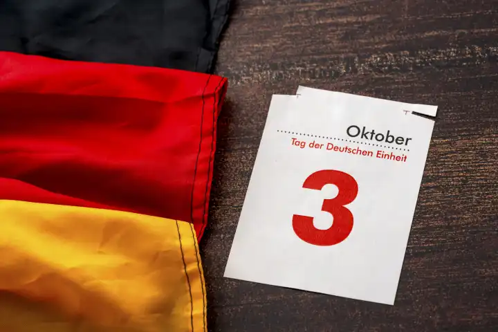 Symbolbild Tag der Deutschen Einheit Feiertag und Brückentag in Deutschland. Kalenderblatt mit 3 Oktober mit Deutschland Landesflagge