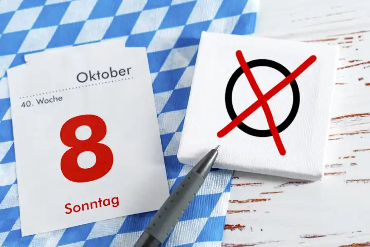 Augsburg, Bavaria, Germany - 7 October 2023: Symbol image for the state election in Bavaria on October 8. Board with Bavarian flag and an election cross and a calendar page with pen FOTOMONTAGE