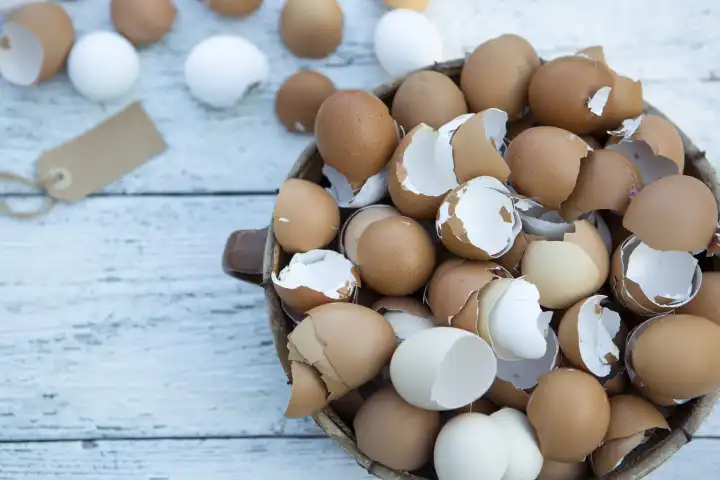 10 February 2023: Easter, broken eggs shells on light wood in a basket