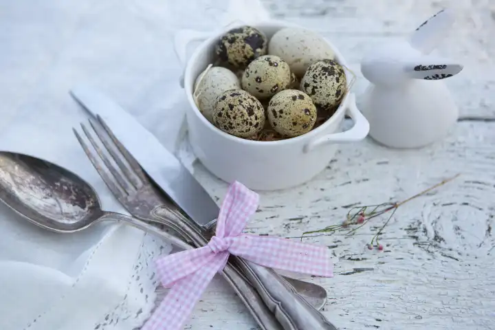 8 February 2023: Easter, napkin with knife and fork with quail eggs and a ceramic Easter bunny