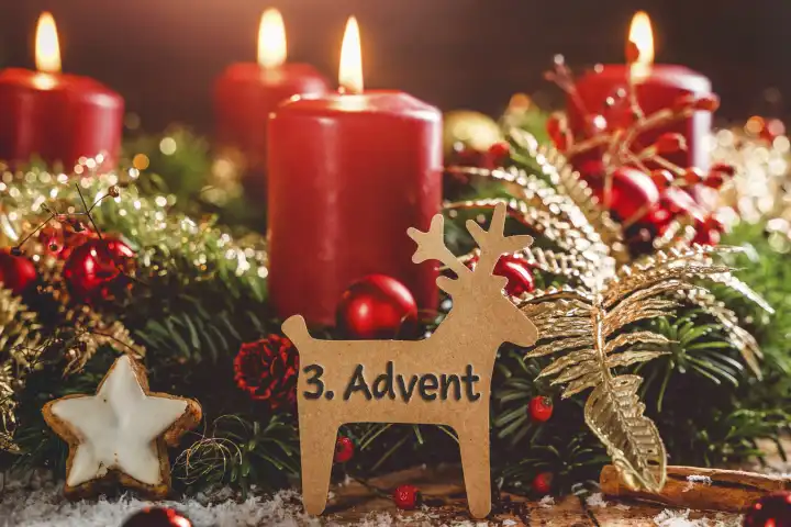 Adventskranz mit brennenden Kerzen zu Weihnachten mit einem Schild in Rentier Form mit Text: 3. Advent (Dritter Advent). Adventszeit Konzept FOTOMONTAGE