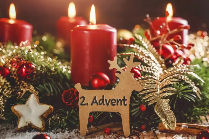 Adventskranz mit brennenden Kerzen zu Weihnachten mit einem Schild in Rentier Form mit Text: 2. Advent (Zweiter Advent). Adventszeit Konzept FOTOMONTAGE
