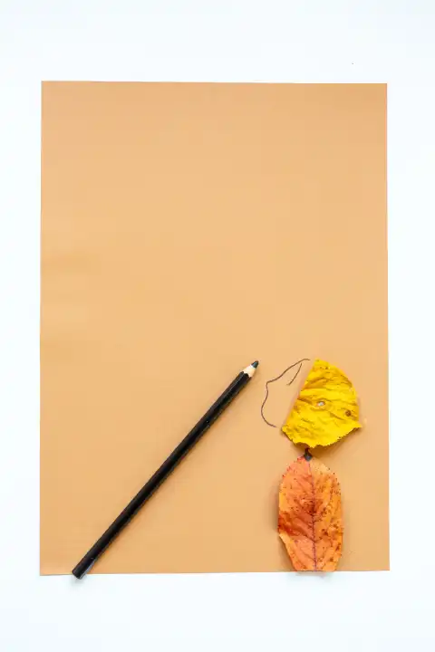 Kreatives Basteln im Herbst, Kunst Material wie Papier, Stifte und Kleber sowie bunte Blätter liegen auf einem Tisch. Kinderbasteln