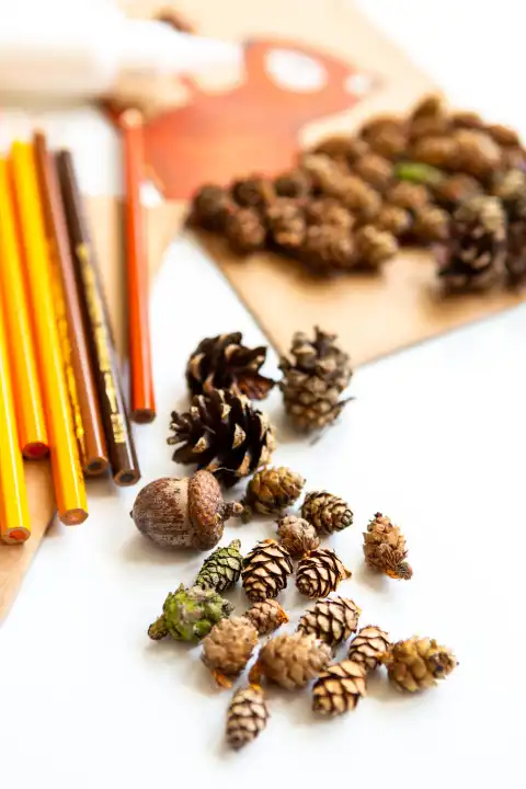 Herbstliche Bastelmaterialien: Kastanien, Blätter und Stifte. Kunst und Kinder Basteln im Herbst mit Tannenzapfen, Kleber und Pappe
