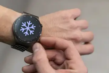 Ein Mann stellt seine Smartwatch Armbanduhr auf Winterzeit um. Symbolbild Zeitumstellung im Herbst FOTOMONTAGE