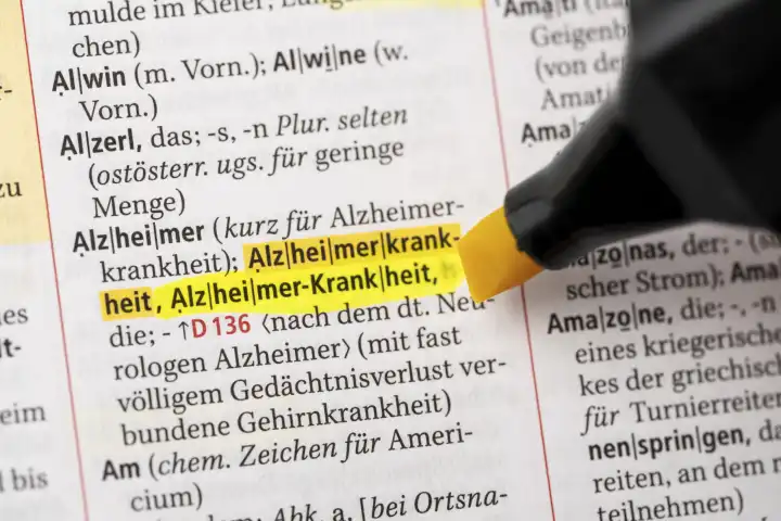 Das Wort Alzheimer-Krankheit in einem Wörterbuch Duden markiert mit einem Stift 