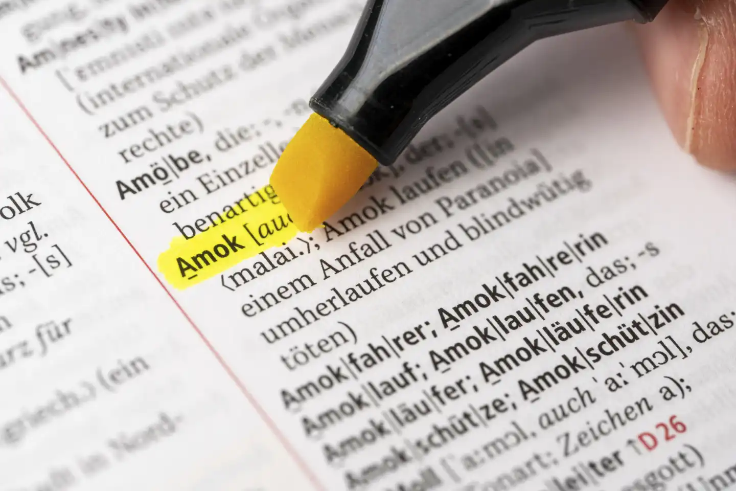 Das Wort Amok in einem Wörterbuch Duden markiert mit einem Stift