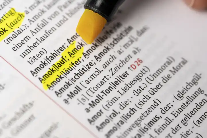 Das Wort Amoklauf in einem Wörterbuch Duden markiert mit einem Stift