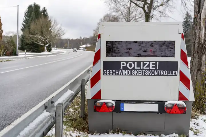 Bavaria, Germany - November 26, 2023: A speed camera trailer of the police on a roadside with the inscription "Polizei Geschwindigkeitskontrolle!", speed trap
