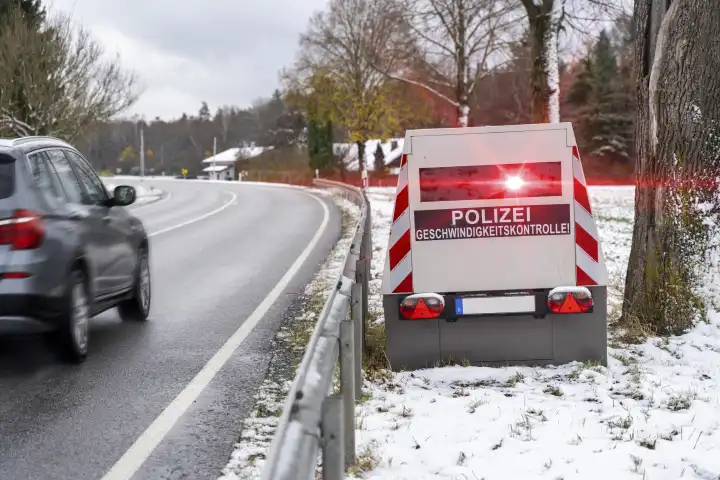 Bavaria, Germany - November 26, 2023: A speed camera trailer of the police on a roadside with the inscription "Polizei Geschwindigkeitskontrolle!", speed trap FOTOMONTAGE