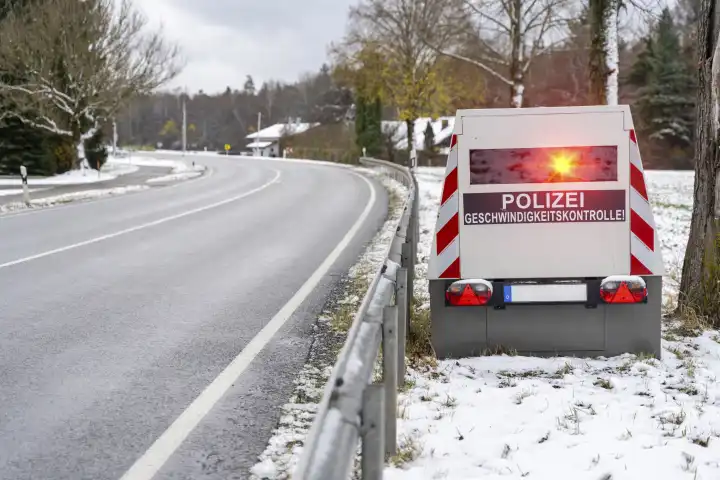 Bavaria, Germany - November 26, 2023: A speed camera trailer of the police on a roadside with the inscription "Polizei Geschwindigkeitskontrolle!", speed trap FOTOMONTAGE