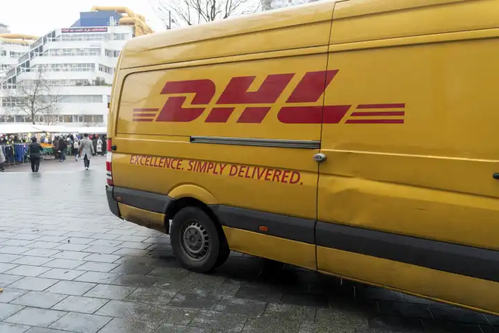 Rotterdam, Netherlands - December 5, 2023: DHL Parcel Service delivery van in a pedestrian zone in Rotterdam