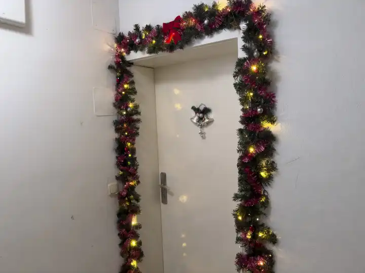 Weihnachtsdekoration an einer Wohnungstüre. Dekorierter Eingang einer Wohnung