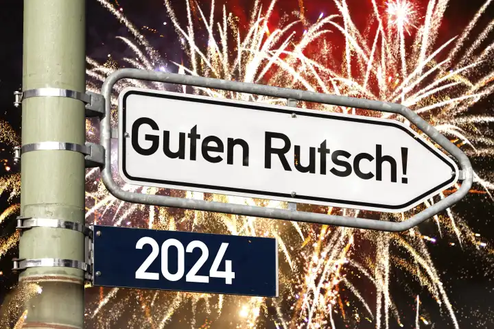 Nachthimmel mit Feuerwerk und ein Wegweiser mit Aufschrift: Guten Rutsch ins Jahr 2024. Silvester und Neujahr Symbolbild FOTOMONTAGE