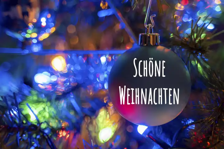 Kammlach, Bavaria, Germany - December 24, 2023: Merry Christmas greeting on a Christmas tree ball on a colorfully decorated Christmas tree. Christmas greeting FOTOMONTAGE