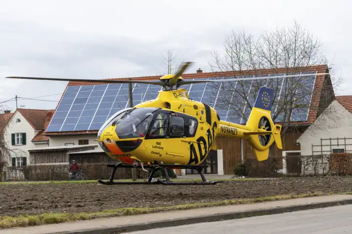 Stettenhofen, Bavaria, Germany - December 28, 2023: Rescue helicopter Christoph 40 of the ADAC Luftrettung lands in a residential area during a mission by the emergency doctor in the village of Langweid OT Stettenhofen