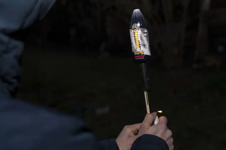 Mann zündet an Silvester eine Rakete Feuerwerk im Garten an