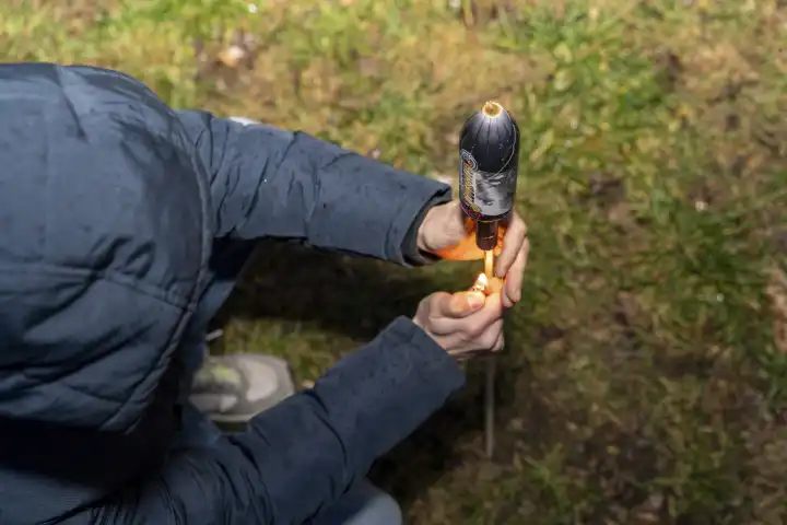 Mann zündet im Garten an Silvester eine Rakete Feuwerk an