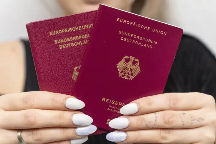 Frau hält Reisepässe der Bundesrepublik Deutschland in der Hand. Deutscher Reisepass