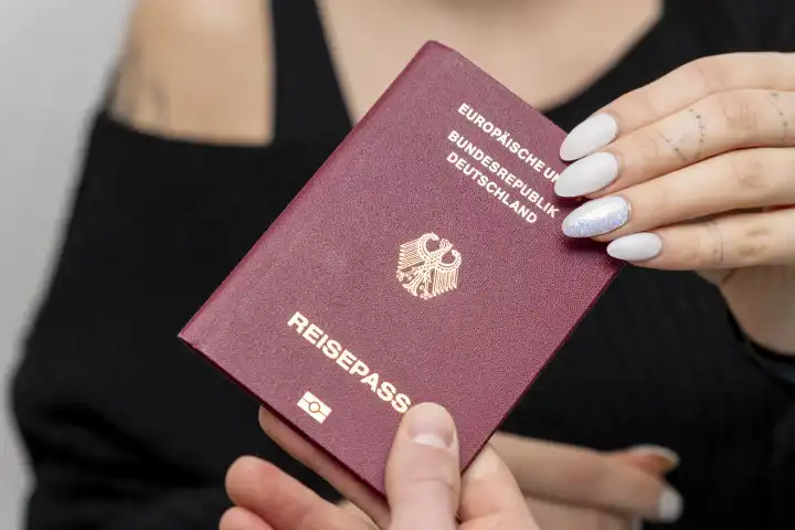 Bavaria, Germany - January 19, 2024: Man gives a woman a German passport
