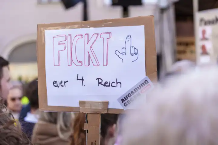 Parolen gegen Rechtsextremismus und Aufruf zum Verbot der AfD - Alternative für Deutschland auf Plakaten und Bannern auf einer großen Demonstration in Augsburg. Verschiedene Menschen protestieren mit Schildern in der Hand für Demokratie unter dem Motto Augsburg ist Bunt und Nie wieder ist Jetzt