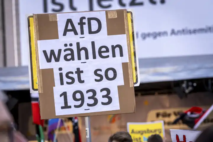 Augsburg, Bavaria, Germany - February 3, 2024: Slogans against right-wing extremism and a call to ban the AfD - Alternative for Germany on posters and banners at a large demonstration in Augsburg. Various people protest with signs in their hands for democracy under the motto Augsburg is colorful and Never again is now