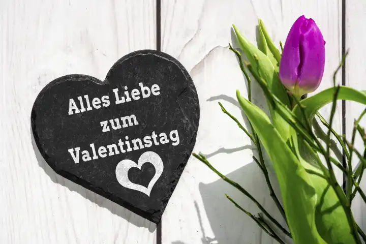 Alles Liebe zum Valentinstag, Gruß auf einem Herz neben einer rosa Tulpe FOTOMONTAGE