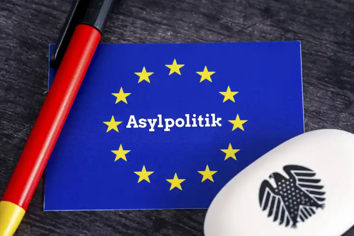 Asylpolitik, Schriftzug auf einem Logo der Europäischen Union. Symbolbild für die Regulierung und Gesetzgebung der Zuwanderung in Europa - Flüchtlingskrise FOTOMONTAGE 