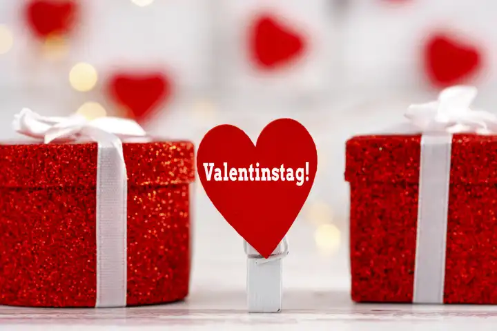 Valentinstag! Schrift auf einem roten Herz neben Geschenken FOTOMONTAGE