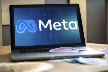 Meta Logo auf dem Bildschirm von einem Laptop Computer zusammen mit Euro Geldscheinen. Aktien und Börsenwert Konzept. FOTOMONTAGE